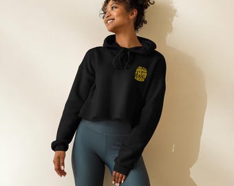 Op de afbeelding: Zwarte getailleerde hoodie met een gouden afbeelding met de tekst "Er is altijd een weg, geen excuus".