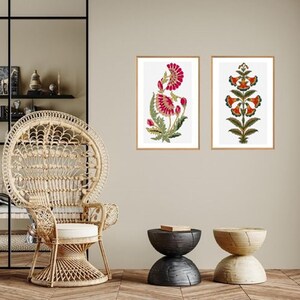 Peut inclure: Deux impressions encadrées de motifs floraux. L'impression de gauche présente une fleur rose avec des feuilles vertes. L'impression de droite présente une fleur rouge avec des feuilles vertes.