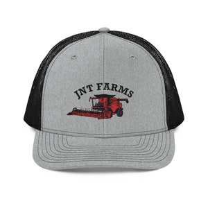 Könnte beinhalten: Eine graue und schwarze Trucker-Kappe mit einem roten und schwarzen Mähdrescher-Motiv und dem Text "JNT FARMS" in Schwarz.