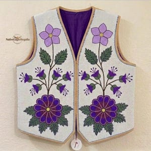 Könnte beinhalten: Eine ärmellose Weste mit weißem, perlenbesetztem Hintergrund und komplexen Blumenmustern in Violett-, Lavendel- und Grüntönen. Das Design zeigt große zentrale Blüten, kleinere Blumen und Blätter. Die Weste hat ein tiefviolettes Innenfutter.