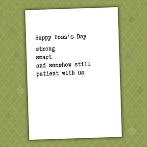 May include: A white rectangular greeting card with black typewriter-style text that reads: Happy Boss's Day, strong, smart, and somehow still patient with us. The card is centered against a light olive green background with a subtle scale pattern.