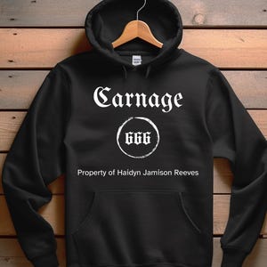 May include: Black hooded sweatshirt with the text "Carnage" in white gothic font, a circle with the number "666" inside, and the text "Property of Haidyn Jamison Reeves" below.