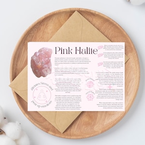 Puede incluir: Cristal de halita rosa con un diseño de mandala rosa y blanco. El texto dice "Halita rosa" y describe las propiedades del cristal. Se dice que alivia el estrés y las emociones reprimidas, fomenta el amor propio y mejora la intuición.