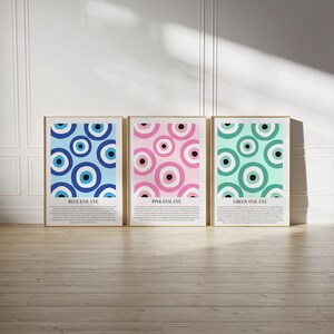 May include: Three framed prints with a pattern of blue, pink, and green evil eyes. Each print has a title: "Blue Evil Eye", "Pink Evil Eye", and "Green Evil Eye".