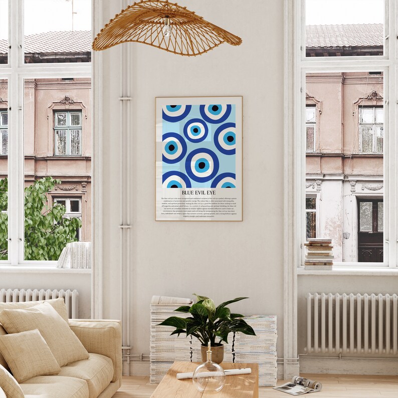 May include: A framed print with a blue and white pattern of evil eyes, also known as Nazar Boncugu, a Turkish amulet believed to ward off the evil eye. The print has the text "BLUE EVIL EYE" at the bottom.