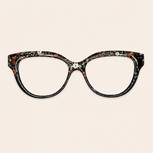 May include: Cat-eye glasses featuring a black frame with a detailed botanical print. The pattern includes small white daisy flowers, orange poppies, and green foliage. A small black cat silhouette is visible on the outer edge of the right frame.