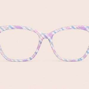 May include: Cat-eye style eyeglasses with a pastel plaid pattern in shades of lavender, blue, and white. The frames have a subtle, curved design, and the lenses are clear. The glasses are set against a soft, peach-colored background.