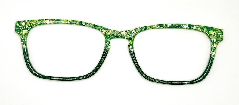 Op de afbeelding: Groene en witte glitterbril met een donkergroene gradi&euml;nt. De monturen hebben een rechthoekige vorm met afgeronde randen. De bril staat tegen een witte achtergrond.