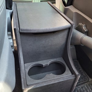 May include: Black wooden car organizer with a storage compartment and two cup holders.