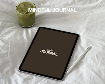 Puede incluir: Una tableta digital marrón con un lápiz blanco y el texto "mindful JOURNAL" en la pantalla. La tableta está sobre una colcha blanca con un vaso de té helado verde en el fondo.