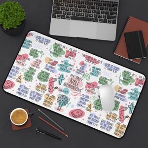 Könnte beinhalten: Ein rechteckiges Mauspad mit weißem Hintergrund mit farbenfrohen Bibel-Affirmationen und Illustrationen. Der Text "My Daily Bible Affirmations" ist deutlich sichtbar. Eine Tastatur, eine Maus und andere Schreibtischartikel sind ebenfalls sichtbar.