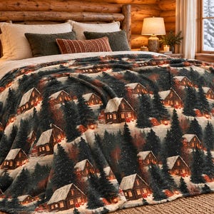 Könnte beinhalten: Eine Plüschdecke mit einem wiederkehrenden Wintermotiv aus dunkelgrünen Tannen und braunen, schneebedeckten Holzhütten. Das Muster zeigt warm leuchtende Fenster in den Hütten und eine weiche, texturierte Stoffoberfläche auf der gesamten Decke.