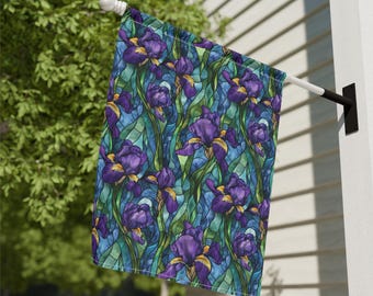 May include: A decorative outdoor flag featuring a stained-glass style design of purple irises with yellow accents against a blue and green background. The flag is mounted on a white pole and is displayed outdoors.