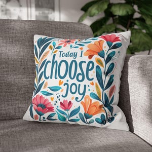 May include: White throw pillow with a floral design and the text "Today I choose joy". The flowers are in shades of pink, orange, yellow, and blue.