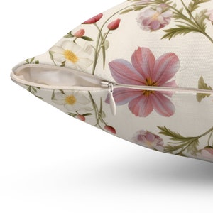 May include: A white pillowcase with a zipper closure features a floral pattern with pink and white flowers on a cream background.