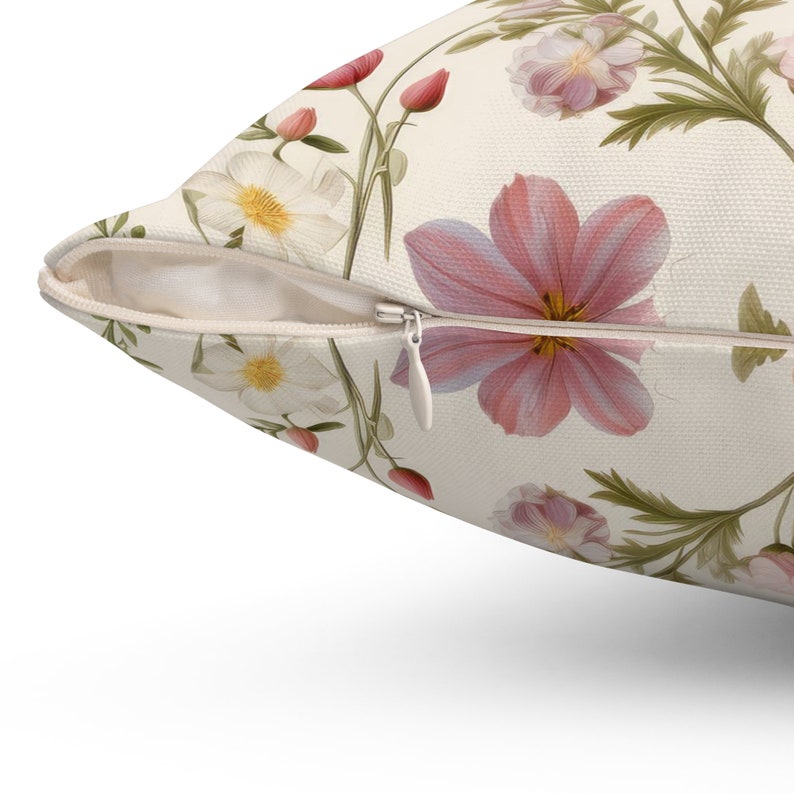 May include: A white pillowcase with a zipper closure features a floral pattern with pink and white flowers on a cream background.