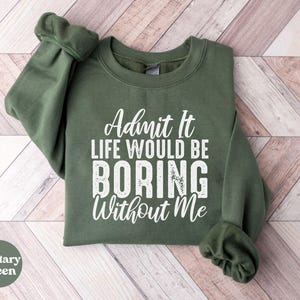 Può includere: Una felpa verde con il testo "Admit it life would be boring without me" in bianco.