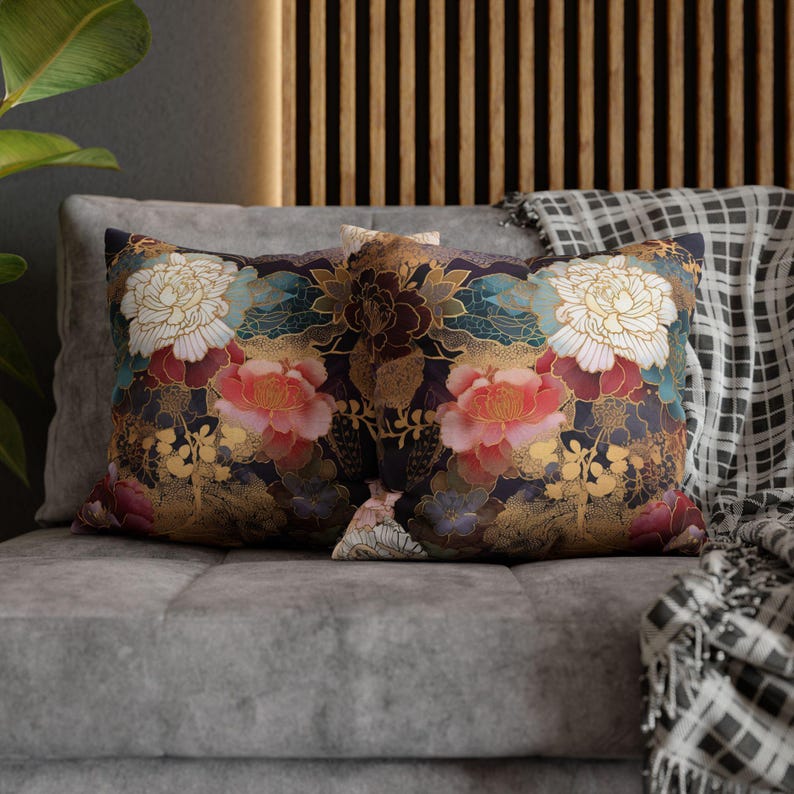 Puede incluir: Dos almohadas decorativas con un patr&oacute;n floral en tonos dorados, blancos, rosas, rojos y azules sobre un fondo oscuro. Las almohadas est&aacute;n en un sof&aacute; gris.