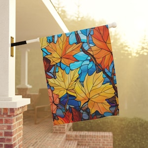 Könnte beinhalten: Eine farbenfrohe Flagge im Stil von Buntglas mit einem Muster aus Herbstblättern in Orange-, Gelb-, Blau- und Rottönen.