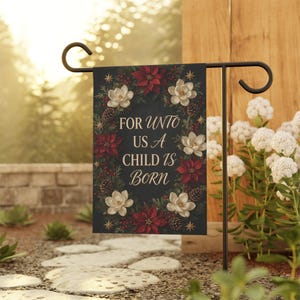 May include: A rectangular garden flag featuring a dark background with a wreath of red poinsettias, white magnolia flowers, pinecones, and small red berries. The text in the center reads, "FOR UNTO US A CHILD IS BORN" in a gold script font.