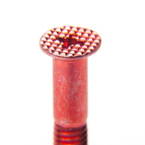 以下が含まれることがあります： テクスチャ加工された円形の頭部を持つ赤いボルトのクローズアップ。頭部は格子状のパターンと中央に小さな穴があります。ボルトのシャフトは円筒形でねじ切りされており、鮮やかな赤色です。