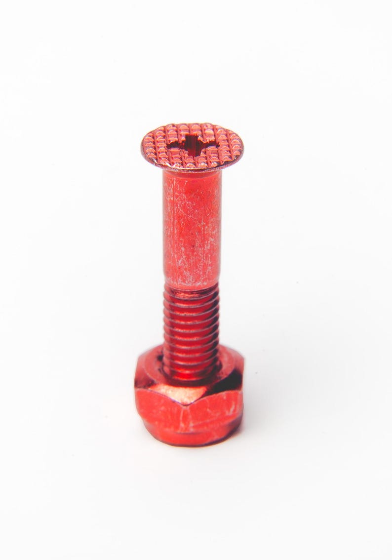 以下が含まれることがあります： 十字型の頭、円筒形のシャフト、六角ナットベースを備えた赤いボルト。ボルトは金属製で、表面はざらざらしています。白い背景にボルトが表示されています。