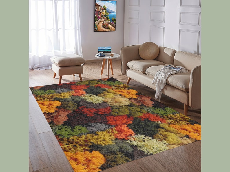 May include: A colorful area rug with a vibrant, abstract pattern. The rug features a mix of orange, yellow, green, and brown hues, creating a textured, natural look. It's placed in a living room setting with neutral-toned furniture and decor.