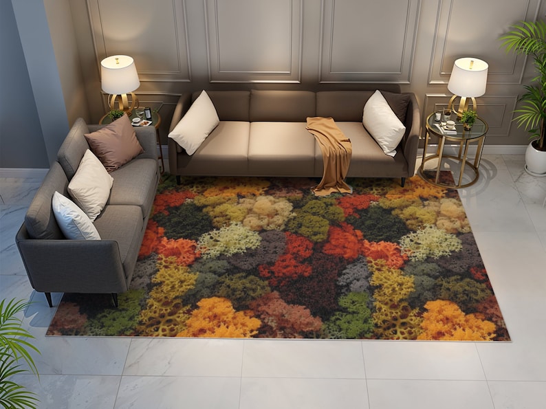 May include: A colorful area rug with a vibrant, abstract floral pattern in shades of red, orange, yellow, green, and brown. The rug is placed in a living room setting with gray sofas and accent tables.