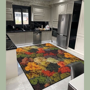 May include: A colorful area rug with a pattern of autumn foliage in shades of red, orange, yellow, and green. The rug is rectangular and placed in a kitchen setting with light gray cabinets and stainless steel appliances.