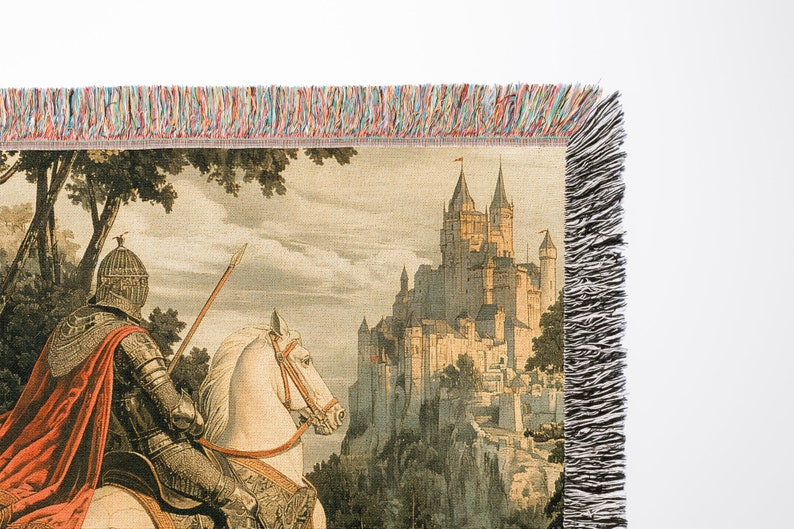 May include: A tapestry featuring a knight on horseback riding towards a large, stone castle. The knight is wearing armor and a red cape. The castle is perched on a hilltop and has many towers. The tapestry has a fringed border.