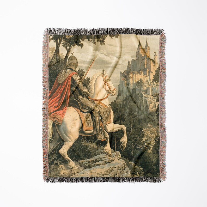 May include: A woven tapestry throw blanket featuring a knight on horseback riding towards a medieval castle. The knight is wearing armor and a red cape, and the horse is white. The castle is in the background and is made of stone.