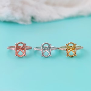 May include: Three oval-shaped ring settings with a pave diamond band. The settings are in silver, rose gold, and gold.