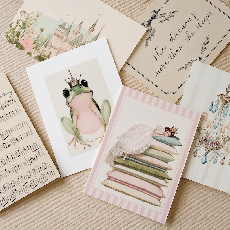 May include: A collection of five rectangular art prints featuring a green frog wearing a crown, a person sleeping on a stack of pillows, a castle, a chandelier, and musical notation with the text "she dreams more than she sleeps" in black script.