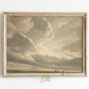 May include: A framed painting of a cloudy sky in shades of gray, white, and pink. The sky is depicted with a dramatic, swirling pattern of clouds. The painting is framed in a light wood frame.