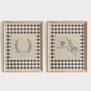 Puede incluir: Dos grabados enmarcados con tem&aacute;tica r&uacute;stica. Uno presenta una herradura, el otro un vaquero montando un potro salvaje. Ambos est&aacute;n esbozados en gris sobre un parche de tela beige, sobre un fondo a cuadros blanco y negro, y enmarcados en madera clara.