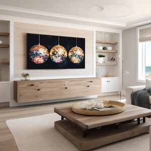 K&ouml;nnte beinhalten: Ein modernes Wohnzimmer mit einem gro&szlig;en Kunstwerk, das drei Mosaik-Diskokugeln zeigt. Der Raum verf&uuml;gt &uuml;ber helle Holzm&ouml;bel, ein wei&szlig;es Sofa und einen Blick auf das Meer. Die Farbpalette ist neutral mit Farbtupfern vom Kunstwerk.