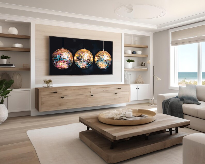 K&ouml;nnte beinhalten: Ein modernes Wohnzimmer mit einem gro&szlig;en Kunstwerk, das drei Mosaik-Diskokugeln zeigt. Der Raum verf&uuml;gt &uuml;ber helle Holzm&ouml;bel, ein wei&szlig;es Sofa und einen Blick auf das Meer. Die Farbpalette ist neutral mit Farbtupfern vom Kunstwerk.