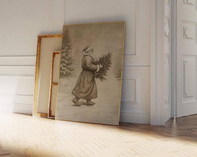 May include: A vintage black and white photograph of a man dressed as Father Christmas carrying a Christmas tree. The image is framed in a gold frame and is leaning against a white wall.