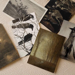May include: A collection of rectangular art prints featuring various illustrations including a black and white drawing of three crows on bare branches, a scene with skeletons in dark clothing, a forest landscape, and a figure holding a broomstick.
