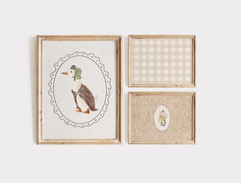 May include: Set of three framed prints. The largest print features a watercolor illustration of a duck wearing a bonnet and vest, set within an oval frame. The other two prints have a gingham pattern and a floral design.