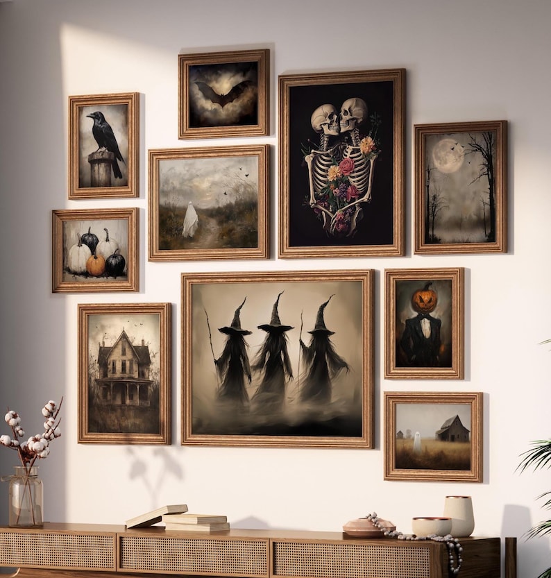 May include: A gallery wall arrangement featuring ten framed art prints with dark, atmospheric themes including skeletons with flowers, three witches, a pumpkin-headed figure, a ghost, a raven, a bat, pumpkins, and old buildings in gold frames.