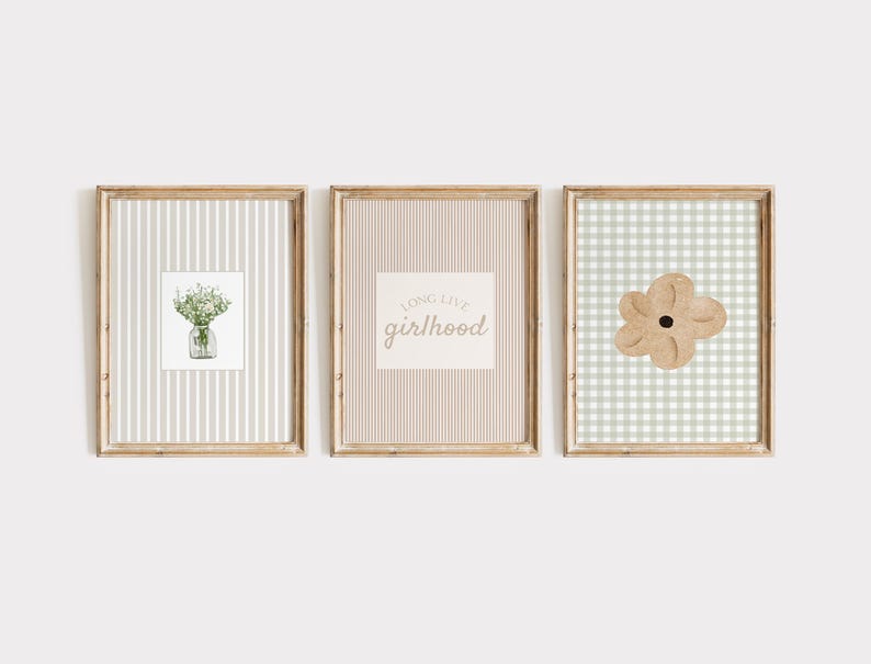 May include: Three framed art prints. The first features a watercolor of flowers in a jar on a striped background. The second has the text "long live girlhood" on a striped background. The third has a flower on a gingham background.