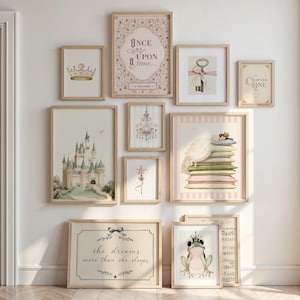 May include: A gallery wall of ten framed prints featuring fairytale illustrations including a castle, a crown, a key, a chandelier, a star wand, a frog with a crown, and text reading Once upon a time, Chapter One, and she dreams more than she sleeps.