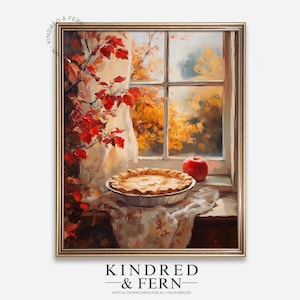 May include: A framed painting depicts a still life scene with a pie, red apple, and window view. The pie sits on a table covered with a patterned cloth. Red leaves and a window with a view of fall foliage are also visible. The painting is signed "Kindred & Fern".