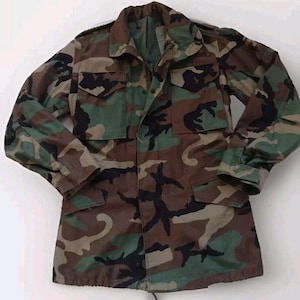 May include: A camouflage green, brown, and black military jacket with a button-up front and two flap pockets.