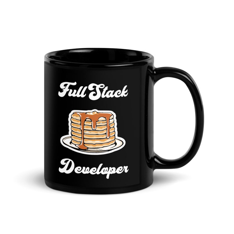 May include: Black ceramic coffee mug with a white graphic of a stack of pancakes with syrup and the text "Full Stack Developer".