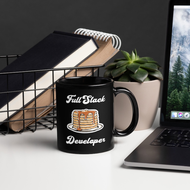 May include: Black coffee mug with a white graphic of a stack of pancakes with syrup and the text "Full Stack Developer".