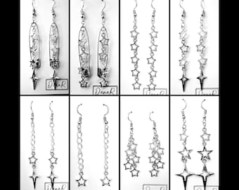 May include: Eight pairs of silver star dangle earrings. Each pair features a different design, including a safety pin, a chain, and a starburst.