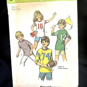 May include: Vintage Simplicity sewing pattern 6479 for boys and girls, size 4. The pattern features illustrations of children in athletic jerseys with numbers. The text includes "SIZED FOR STRETCH KNITS ONLY".