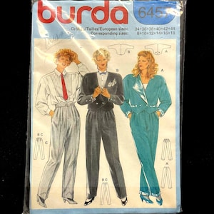 May include: A Burda sewing pattern packet featuring illustrations of women's suits. The suits include a white shirt with a red tie, a black suit with a bow tie, and a teal suit. The packet has the number 6453 and size information.